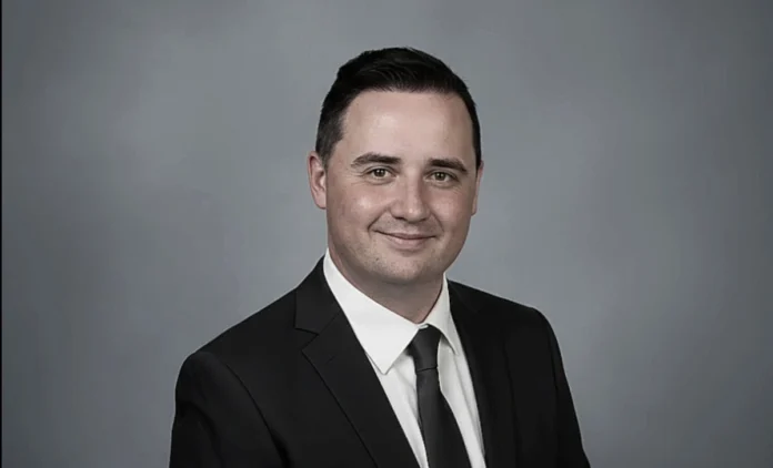 Kyan Peffer – Albany County Public Defender Kyan Peffer Public Defender standing in Albany County courthouse hallway holding legal documents