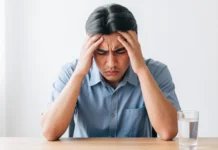 Dehydration Headache Symptoms and Relief: What Actually Works Person holding their head in pain next to a glass of water — dehydration headache symptoms and relief