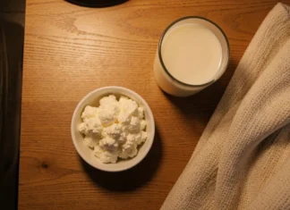 Protein Before Bed Sleep: Does It Help or Hurt Deep Sleep? Bowl of cottage cheese and warm milk on a bedside table at night — protein before bed sleep foods for better deep sleep