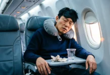 Window Seat Sleep Problems: Why You Can’t Rest on Long Flights Exhausted traveler experiencing window seat sleep problems on long flight