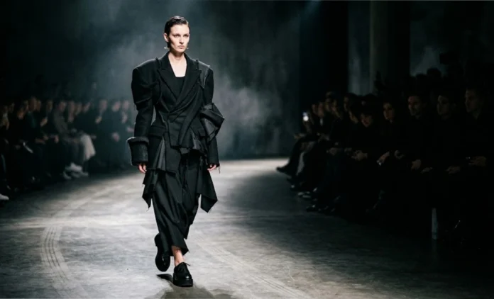 Avant Garde Fashion Runway Look — Rei Kawakubo Style Avant Garde Fashion model wearing asymmetrical deconstructed blazer, oversized silhouette, bold sculptural runway design