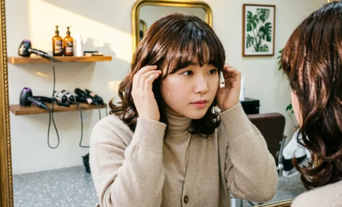Do Bangs Make Face Look Fatter – Curtain Bangs on Round Face Do bangs make face look fatter — woman with round face trying curtain bangs in salon mirror
