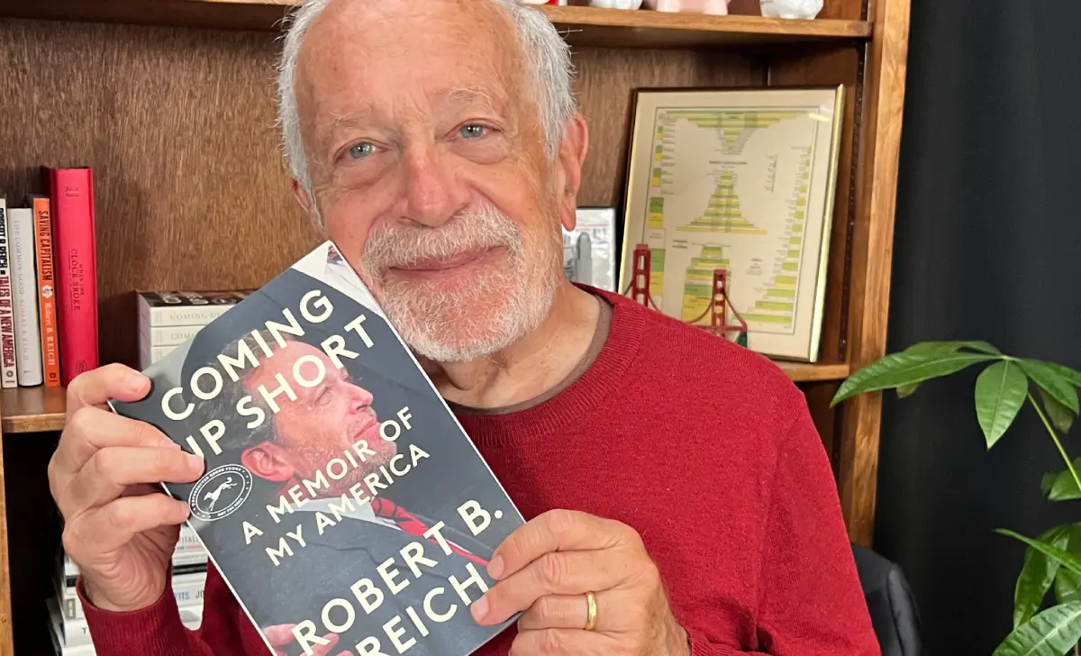 Robert Reich Net Worth from books and documentaries — stacked books and streaming documentary on laptop