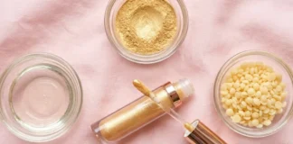 What is lip gloss made of — flat lay of gloss tube, castor oil, mica, and wax used in lip gloss ingredients.