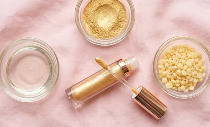 what-is-lip-gloss-made-of-ingredients-flatlay What is lip gloss made of — flat lay of gloss tube, castor oil, mica, and wax used in lip gloss ingredients.