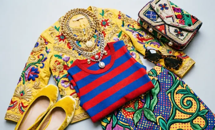 Maximalist Outfits Starter Kit Inspired by Iris Apfel Maximalist outfits flat-lay with mixed prints, bright colors, embroidered jacket, striped top, patterned trousers, and stacked accessories inspired by Iris Apfel.