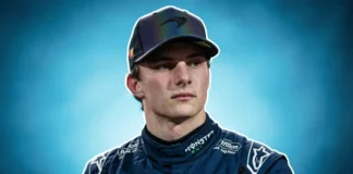 Formula 1 driver in McLaren racing suit standing beside race car, representing Oscar Piastri net worth 2026
