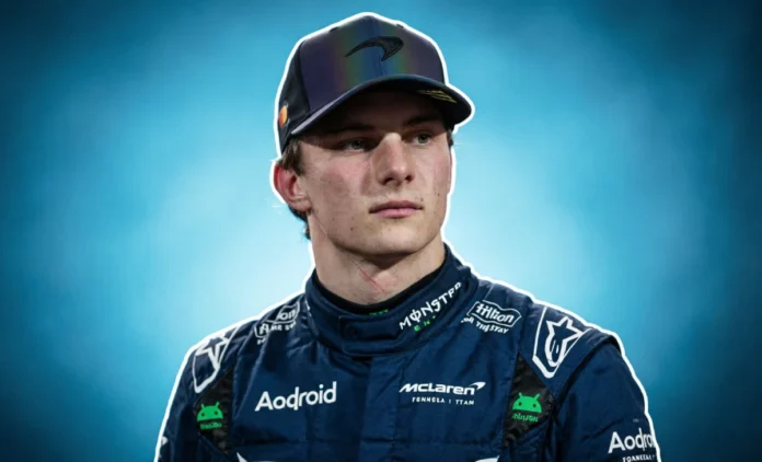 oscar-piastri-net-worth-mclaren-2026 Formula 1 driver in McLaren racing suit standing beside race car, representing Oscar Piastri net worth 2026