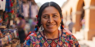 Woman wearing traditional Mexican clothing, a colorful embroidered huipil with floral patterns.